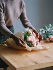 African American florist in process of creating a bouquet of flowers