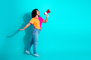 Young woman with a megaphone enthusiastically gesturing against a vivid turquoise background