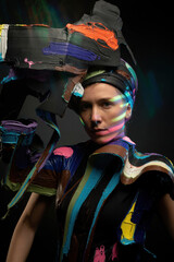 Striking Modern Art Portrait of a Woman with Abstract Colorful Makeup and Sculpture-Style Attire in Dramatic Lighting