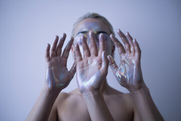 Artistic Expression of Hands with Iridescent Reflection Against a Soft White Background