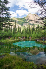 Altai republic, Russia - 26 July 2020: Tourists at Geyser blue lake in which fountains at the bottom color blue circles in the vicinity of the village Aktash, Altai Mountains