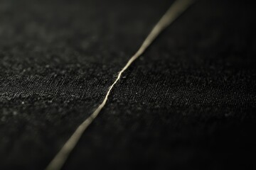 Close-up view of a subtle seam in dark fabric.