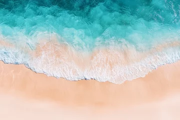 Fotobehang High-angle view of a beach's turquoise waves crashing on light sand. © AlparadiseDesign