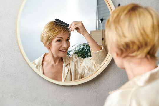 Beautiful senior woman joyfully combing her short blonde hair in a cozy morning setting