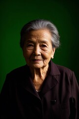 Obraz premium an older woman with a black shirt and a green background