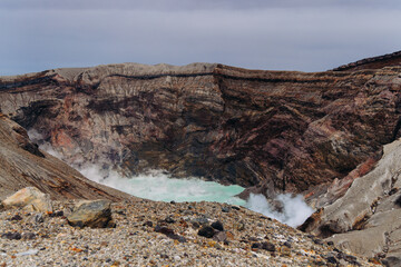 Mount Aso Nakadake volcano crater, Aso-San, caldera, Aso-Kuju National Park hiking, Kyushu island region, Kumamoto prefecture, Japan, eruption with steam and smoke, volcanic desert landscape view © tsuguliev