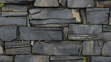 Dark gray stone wall constructed from irregular rectangular blocks.