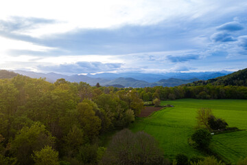 Obraz premium spectacular aerial view of Garrotxa region in Catalonia, Spain, at sunset with cloudy sky. Scenic view of natural landscape nearby Olot