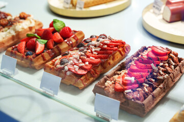 Delicious variety of waffles topped with fresh fruits in a dessert display