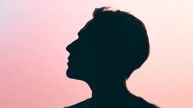 Dark silhouette profile against pink backdrop, person gazing upward with serene expression, evoking contemplation and inner peace