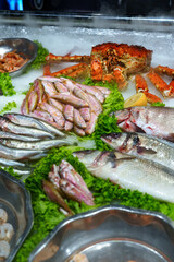 Fresh seafood display at a bustling market showcasing various fish and shellfish on ice