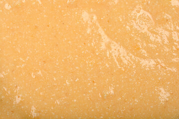 Naklejka premium A textured, pale yellow mixture of eggs and semolina is shown in a detailed close-up, ready to be formed into dumplings for soup
