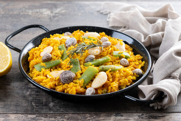 Traditional Valencian paella with rabbit, chicken, garrofon beans, snails, Moroccan green beans and...