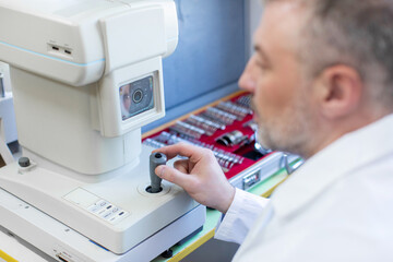 Professional male ophthalmologist conducting an eye examination with modern ophthalmologic device...