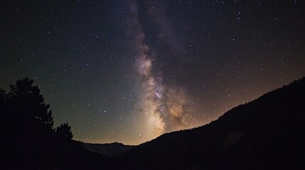 Naklejka premium Majestic Milky Way Galaxy over Silhouetted Mountains at Night