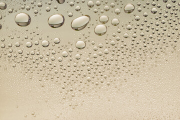 Cosmetic moisturizing liquid drops on grey beige pastel background. Toner or lotion. Collagen or hyaluronic acid serum, toner, tonic, mist