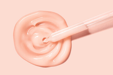 Cosmetic beauty product sample swatch. Liquid peach orange gel or serum on same colored background