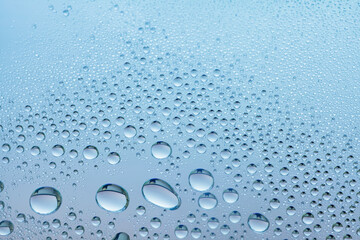 Cosmetic moisturizing liquid drops on blue pastel background. Toner or lotion. Hyaluronic serum