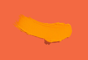 Cosmetic make-up product yellow pigment paint swatch isolated on red orange background