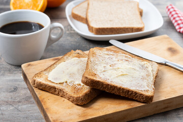 Sliced fresh bread and butter on wooden table