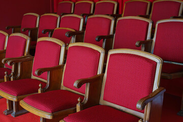 Obraz premium Empty rows of retro, old red theater or cinema seats. Old style, vintage chairs with red upholstery in concert hall.