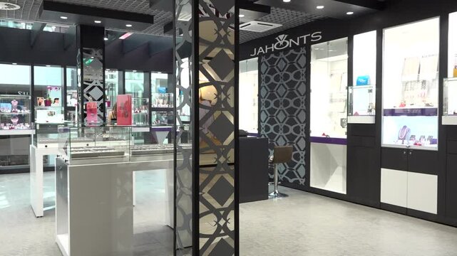 Modern jewelry store interior with glass display cases, elegant decor, and illuminated showcases filled with accessories and ornaments.
