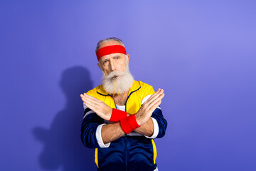 Funny sportsman in retro outfit posing with crossed arms against a vibrant purple background, embracing fitness and vintage style.