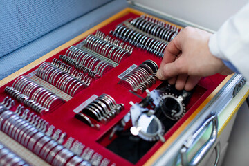 Ophthalmologist man preparing optical instruments for eyesight vision test in clinic, closeup