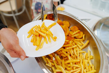 Heated tray with french fries and nuggets. Banquet food delivery.