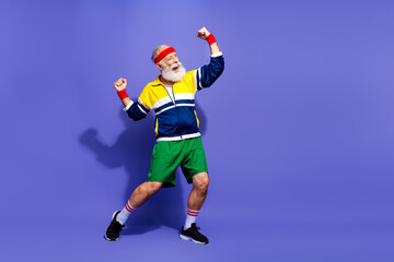 Naklejka premium Mature man in colorful retro sportswear celebrating with enthusiasm against a vibrant backdrop