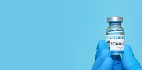 Doctor wearing protective medical gloves holding a Rotavirus vaccine vial, symbolizing healthcare,...