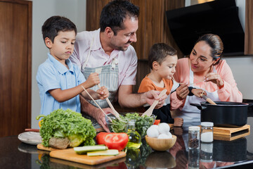 latin family parents cooking with children at kitchen in home in Mexico Latin America, father and mother with son preparing food	