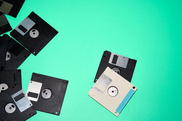Overhead view of old black and white floppy disks placed on blue background in studio