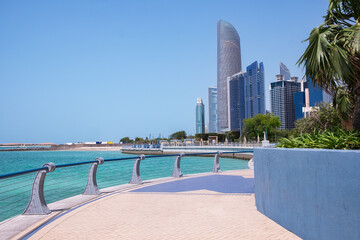 Corniche promenade in Abu Dhabi, UAE. Beautiful walkway in urban city park with green trees