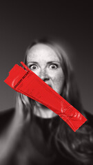 Angry woman with long red grocery receipt covering her mouth, with shocked expression reflecting...