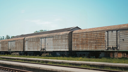 Obraz premium Close up view of old freight train at railway station in urban environment