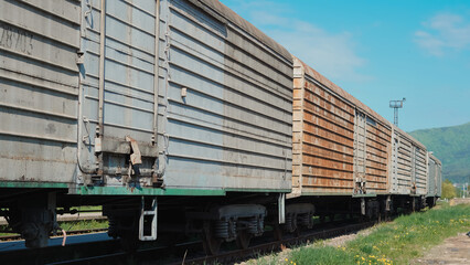 Obraz premium Close up view of old freight train at railway station in urban environment