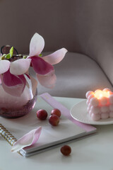still life with blooming magnolia wreath in glass vase