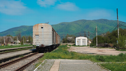 Old freight train at the station with mountain background in sunlight
