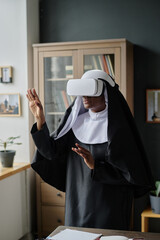 Vertical shot of African American nun in black and white habit gesticulating in air while playing...