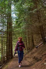 Obraz premium Woman hiking on forest trail