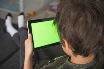 Boy using social media on tablet with chroma key background. touchscreen device for social networks browsing