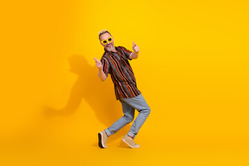 Stylish Mature Man Giving Thumbs Up on Yellow Background with Trendy Outfit and Dyed Hair
