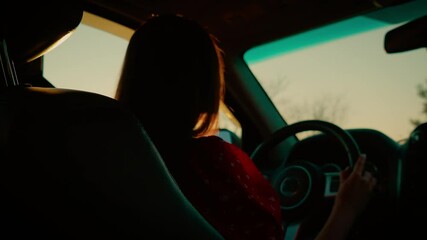 Cinematic shot woman driving car during sunset with dramatic lighting. Silhouette highlighted by warm golden hues as she holds steering wheel. Capturing serene mood of evening drive with focus on