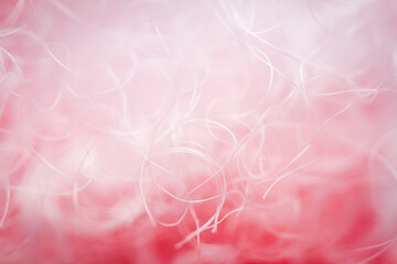 Extreme macro of polyester stable fiber on red background. Selective focus, shallow depth of field. Abstract dreamy background