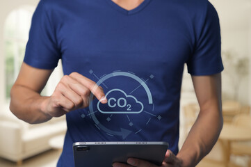 Person using tablet to track carbon dioxide emissions in home