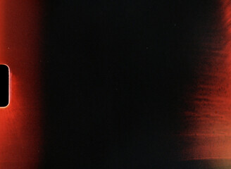 Dark empty film frame showing light leaks and film grain