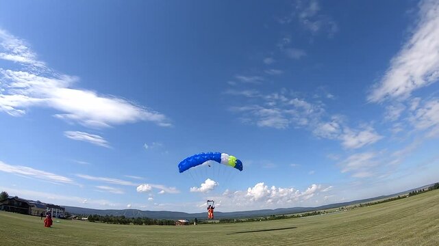 A girl and the instructor land on the ground after a parachute jump