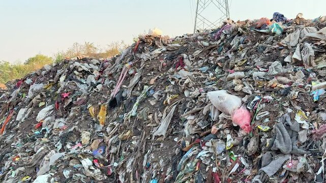 tracking shot of a pile of garbage at the dump yard, microplastic pollution