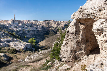 Cave on cliff with cliffs with buildings on the Gravina di Matera of Matera, Italy, know for the Sassi or Ancient town with its rock-cut urban core and twin cliffside zones, collectively the Sassi